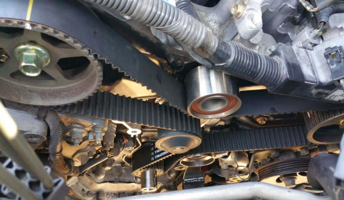 Photo of automotive serpentine belt being replaced by mobile auto repairman.