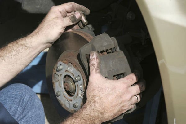 Photo of mobile mechanic resetting the caliper when doing a brake job in Huntington Beach.