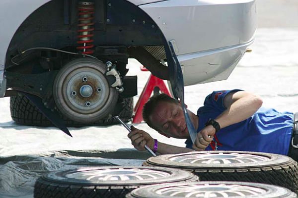 Photo of mobile mechanic working on rear axle/hub of a car.